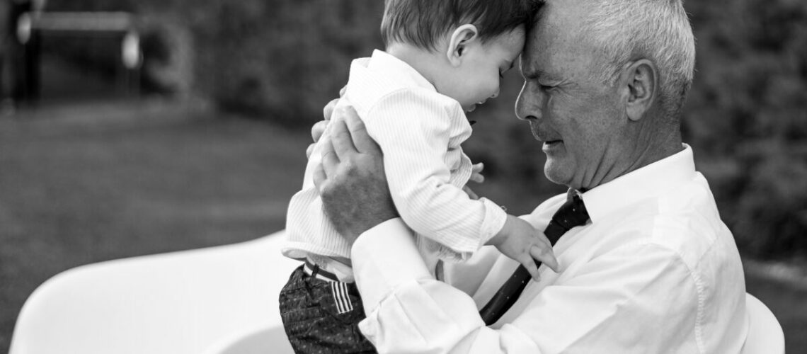 elderly man holding a young boy