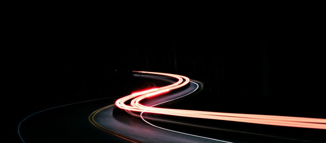 Time lapse of a car's tail lights on a winding road